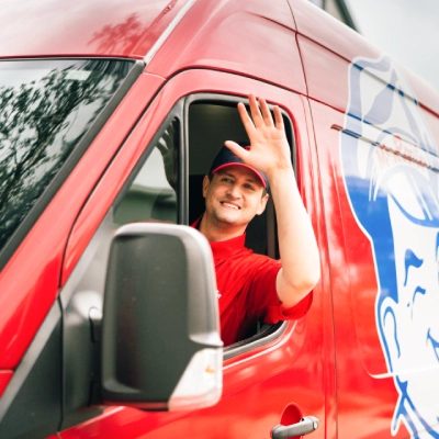 Mr. Rooter professional waving from a branded van.