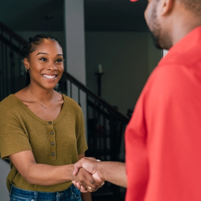 Mr. Rooter professional shaking a customer's hand.