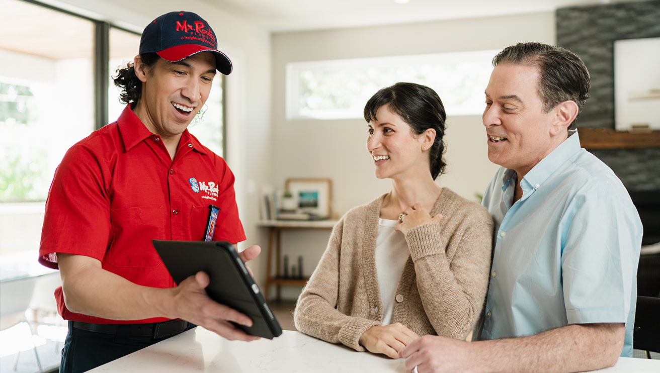 Mr. Rooter technician showing customer's a tablet screen.