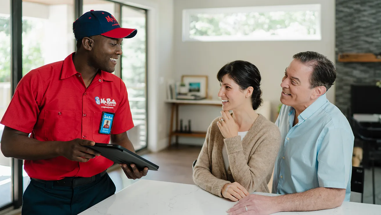 Mr. Rooter professional going over bidet installation service costs with two customers.