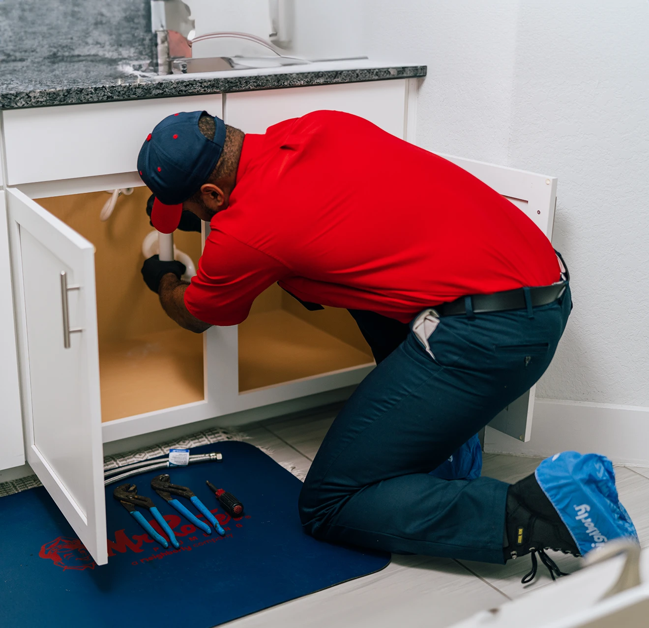 Mr. Rooter professional repairing a sink drain.