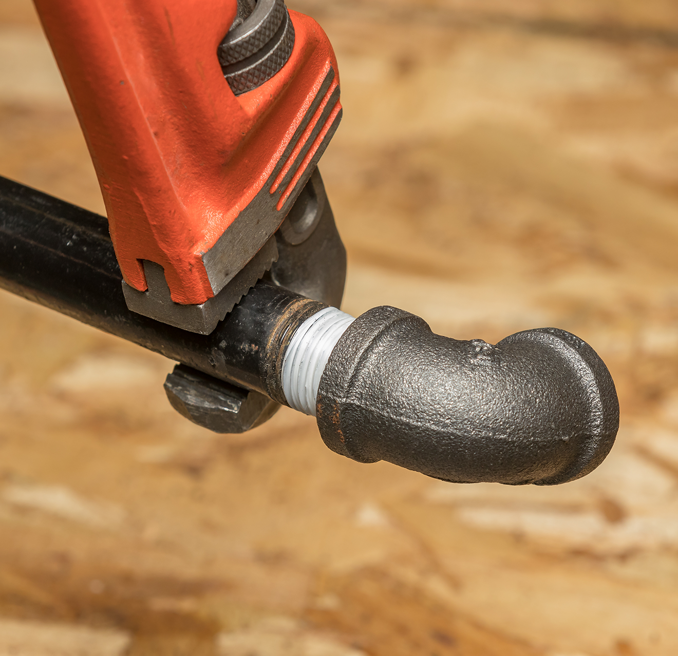 Image of a wrench tightening a pipe.