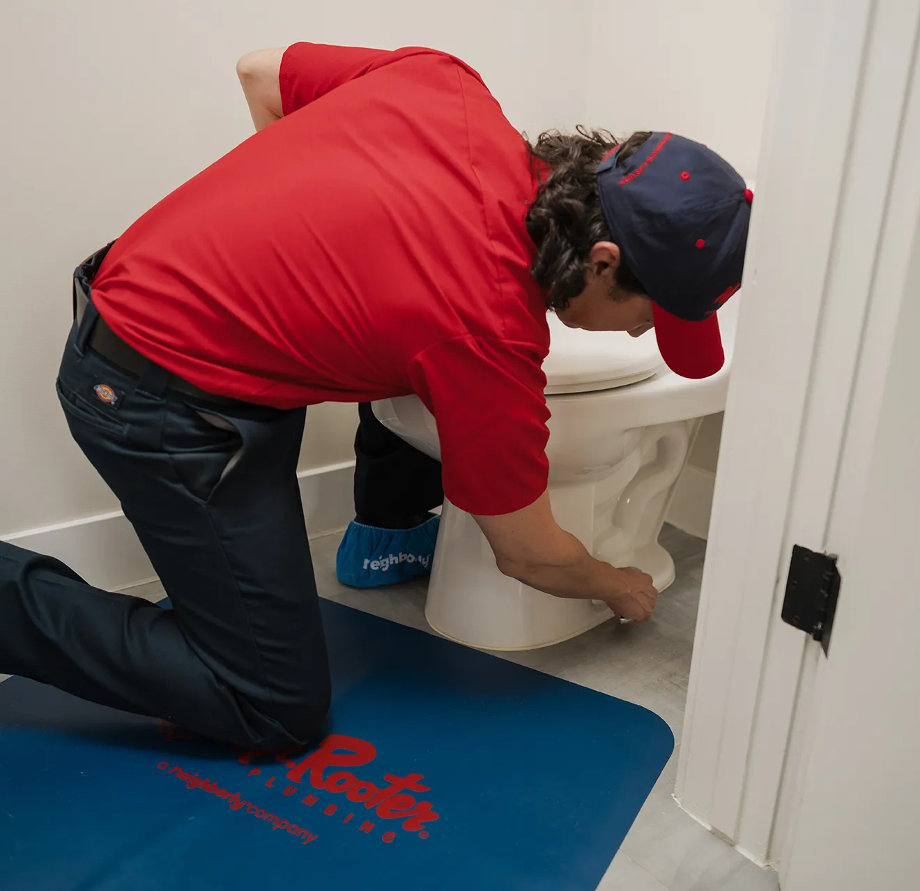 Mr. Rooter technician working on fixing a toilet.