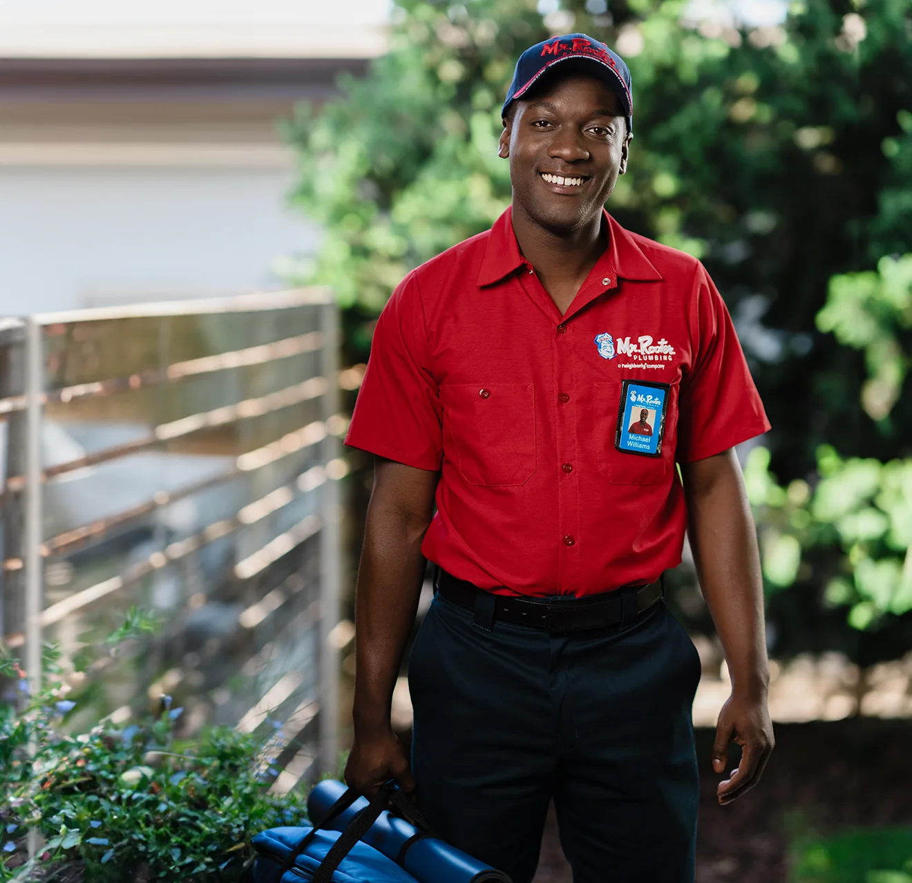 Mr. Rooter professional standing outside of a home.