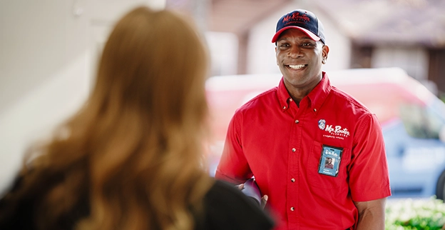 Customer greeting Mr. Rooter professional at the front door.