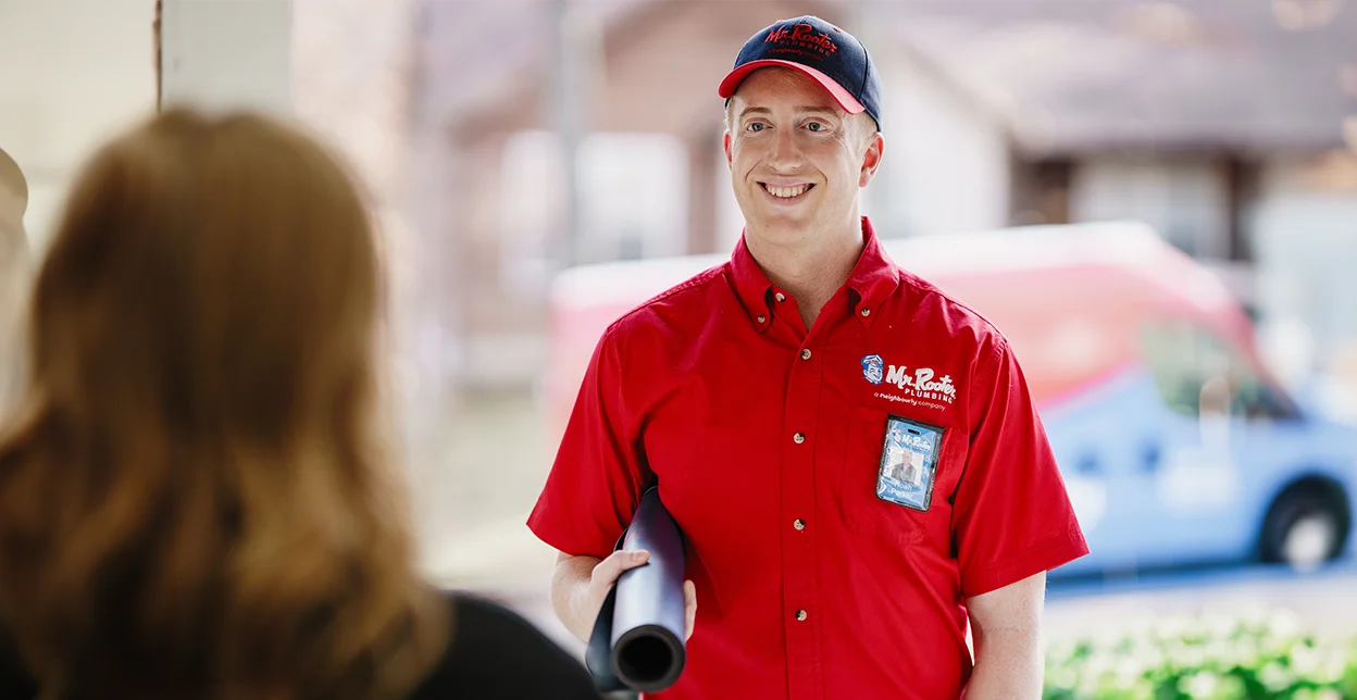 Smiling Mr. Rooter technician arriving at a business.