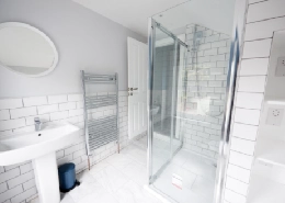 Modern bathroom with grey walls and glass shower.