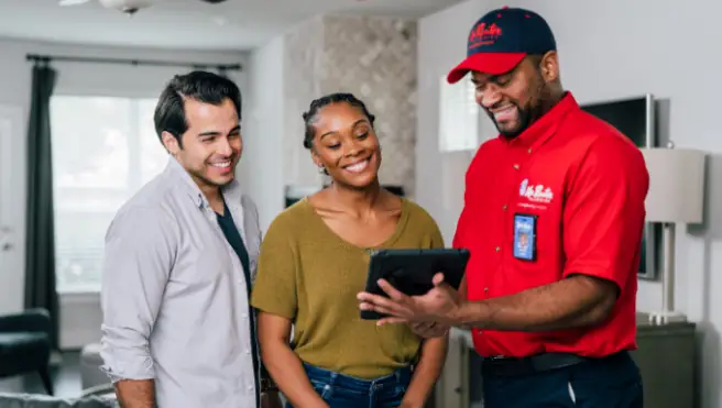 Mr. Rooter technician using a tablet to show a couple their service options.