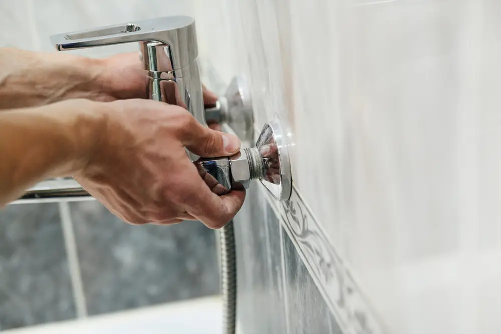 Plumber replacing a bathtub faucet.