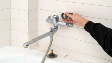 Mr. Rooter Plumbing technician repairing leaking shower faucet in Mississauga home 