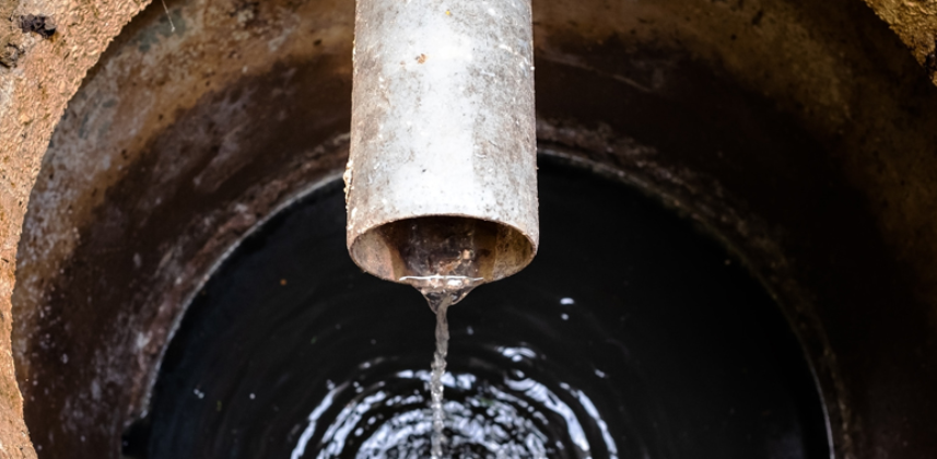 Water pouring through a clogged pipe